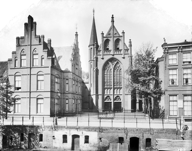 835442 Gezicht op de St.-Martinuskerk (Oudegracht 401) te Utrecht, met links de pastorie (Oudegracht 403).